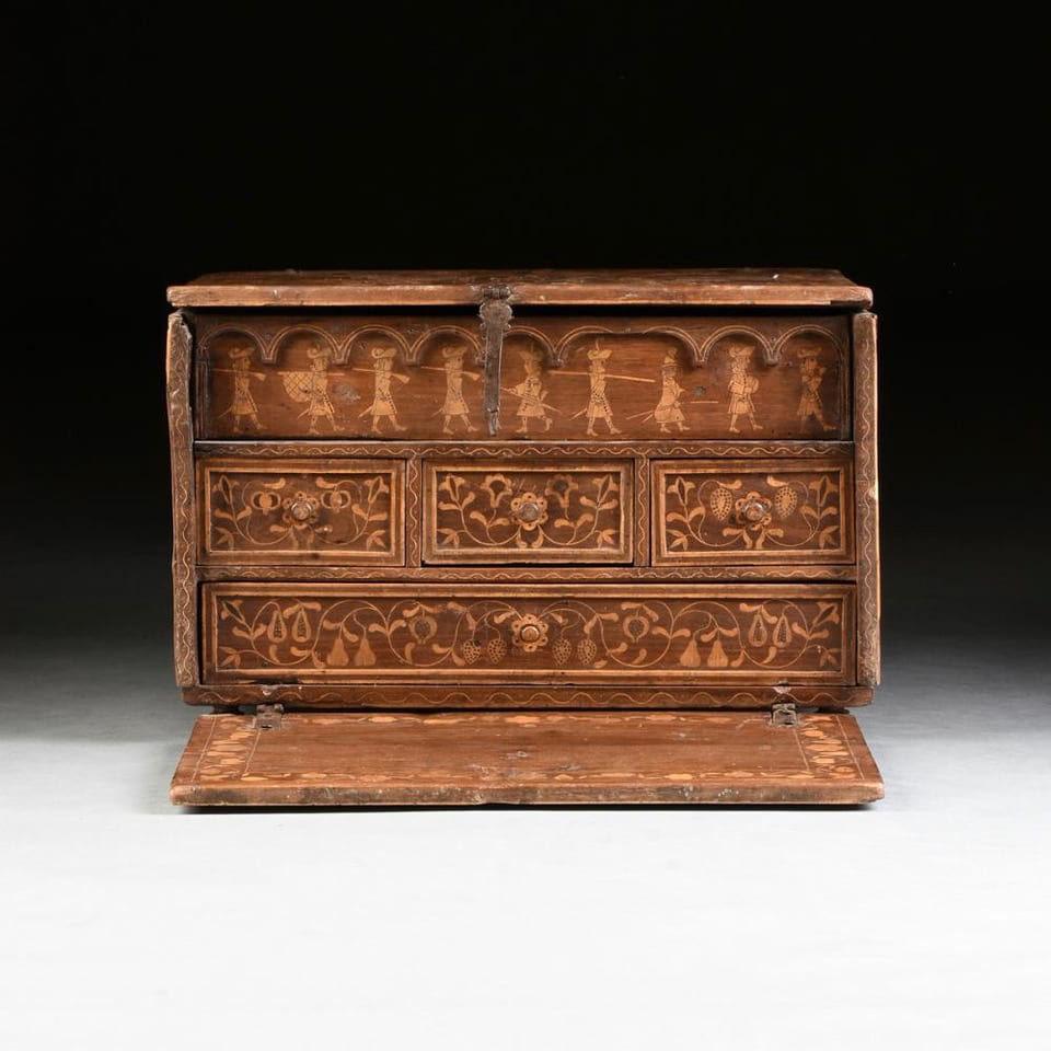 Antique wooden chest with intricate carvings and open lid.